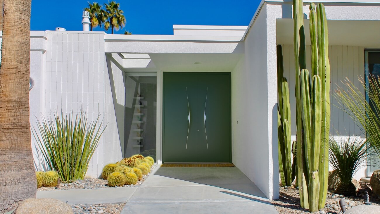 Green front doors with a white facade